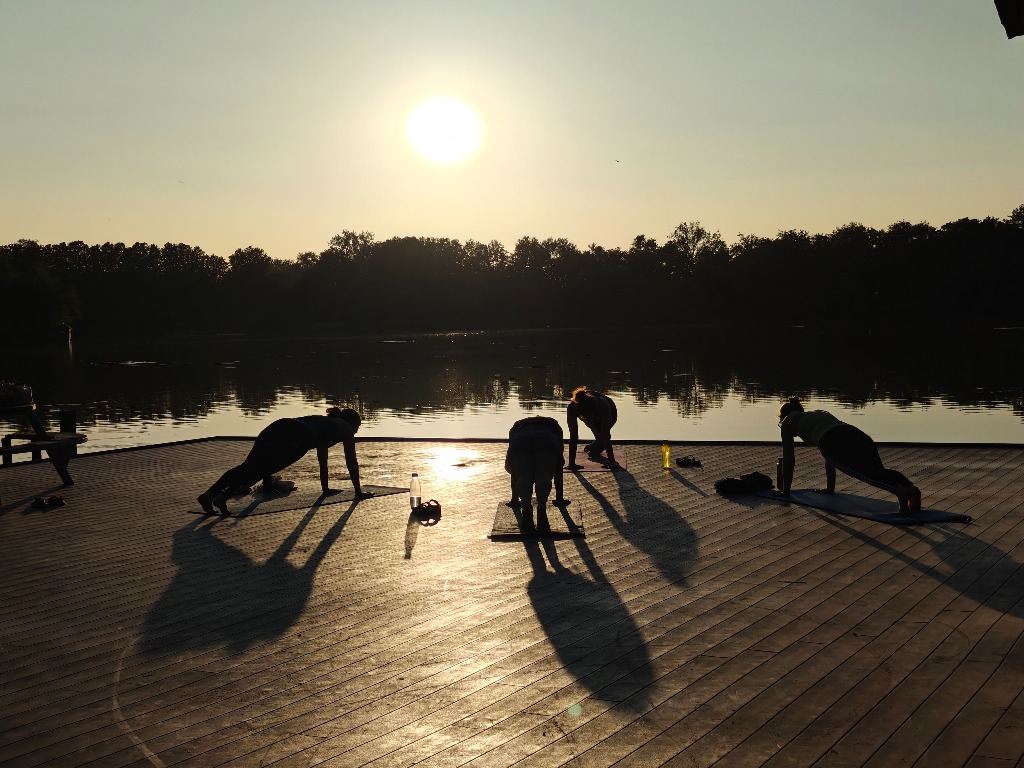 Recharge - People practicing yoga at sunrise by the water